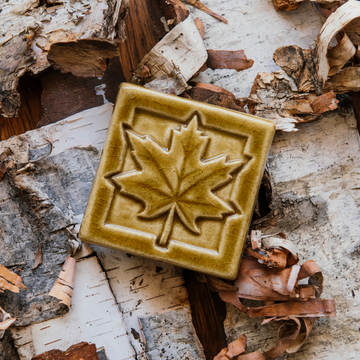 The tile features a large maple leaf with delicate veins reaching out the the tips of its ends. This tile has a simple square border.