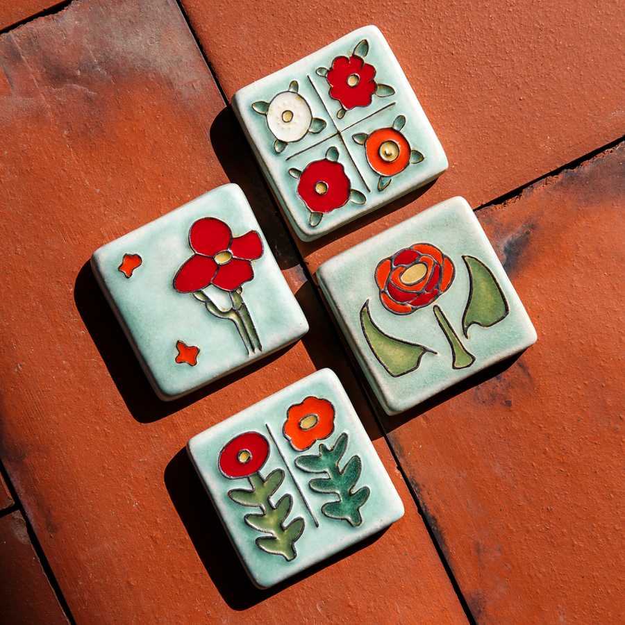 The Two Flowers Tile is on a bright red brick background with the other tiles in the Poppy color palette - the Rose Tile, the Cactus Flower Tile and the Four Flowers Tile.