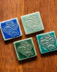 All four glaze types are represented in this image. Celadon, Pewabic Blue, Periwinkle, and Emerald.