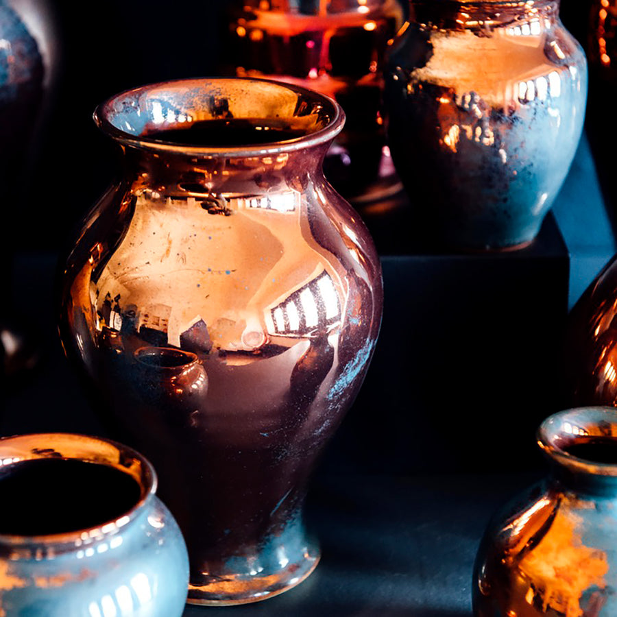 The Copper iridescent glaze is a shiny, smooth metallic glaze with many variations. Some pieces end up with a blue-gray flashing of color that covers a portion of the surface.