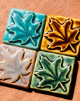 The four color options of the maple leave tile are positioned together with each leaf spreading in a different direction.