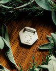 The back of the pin is stamped with Pewabic's logo and the word "Detroit". A small silver pin back has been attached to the small tile's surface.