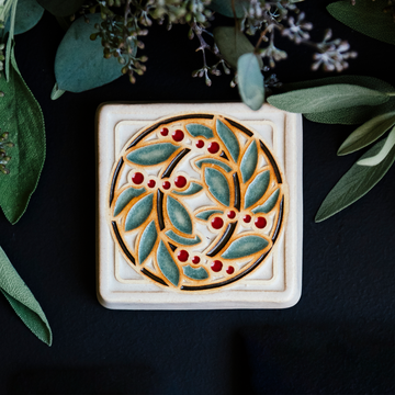 The DIA Leaf and Berries tile features two intertwined branches with round berries that create a circle at the center of the tile. The thick lined border makes the tile into a square. This tile features Style D with red berries, pale green leaves, brown stems and a white background.