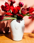 The Pinecone vase features smooth sides with three high relief pinecones and pine needles near the lip of the vessel. Each pinecone points in a different direction so there is always one pinecone pointed outward no matter which direction the vase is sitting. The top of the vase has a simple raised lip that come in toward the center.