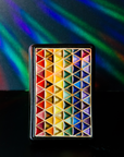 The 4x6 Pride Tile features lines of interlocking triangles, the colors on the triangles start at red and end in indigo- creating the rainbow Pride flag. The bright pattern is contained in a black border.