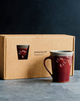 Cafe Mugs have a simple, modern design with smooth, straight sides that slant out. This makes the base slightly smaller than the cup's opening. The round Pewabic logo is stamped onto the side. This set of two mugs come in a specifically designed gift box.