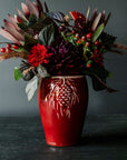 The Pinecone vase features smooth sides with three high relief pinecones and pine needles near the lip of the vessel. Each pinecone points in a different direction so there is always one pinecone pointed outword no matter which direction the vase is sitting. The top of the vase has a simple raised lip that come in toward the center.